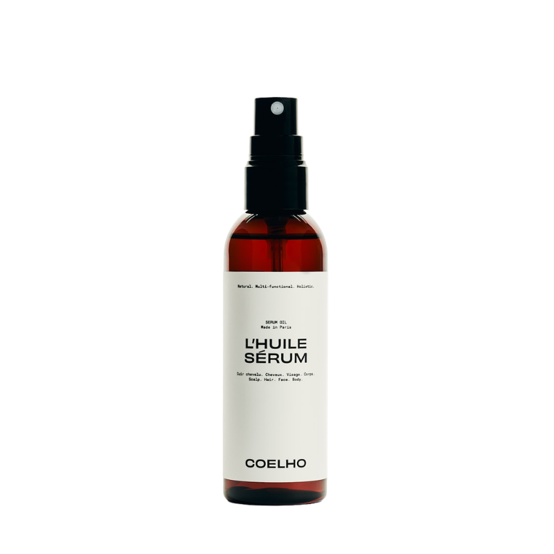 A bottle of Coelho L'Huile Sérum hair oil with a black spray nozzle and a white label, set against a plain white background.