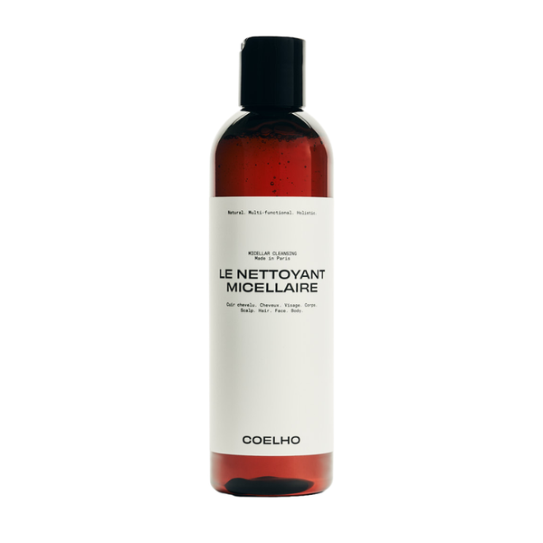 A bottle of Coelho Le Nettoyant Micellaire hair cleanser, featuring a white label and black cap, containing a reddish-brown liquid, shown on a plain white background.
